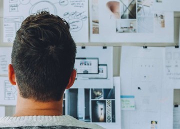 man looking at whiteboard with notes
